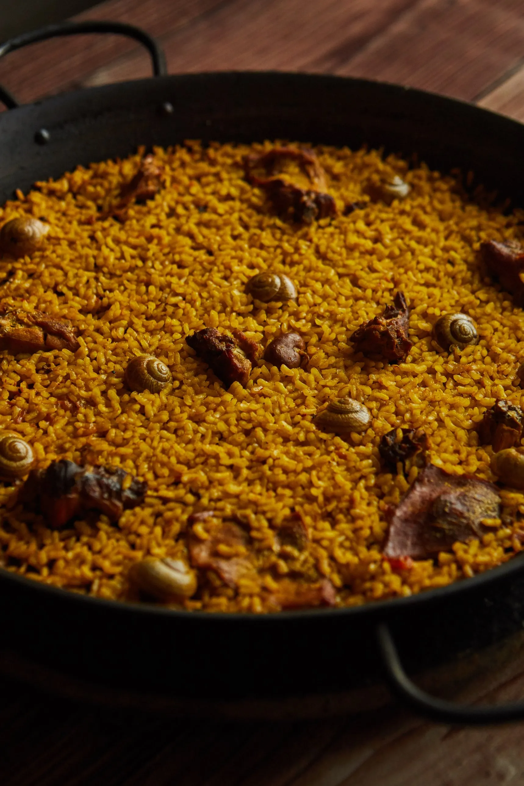 Freshly made rabbit and snail rice in an iron paella pan