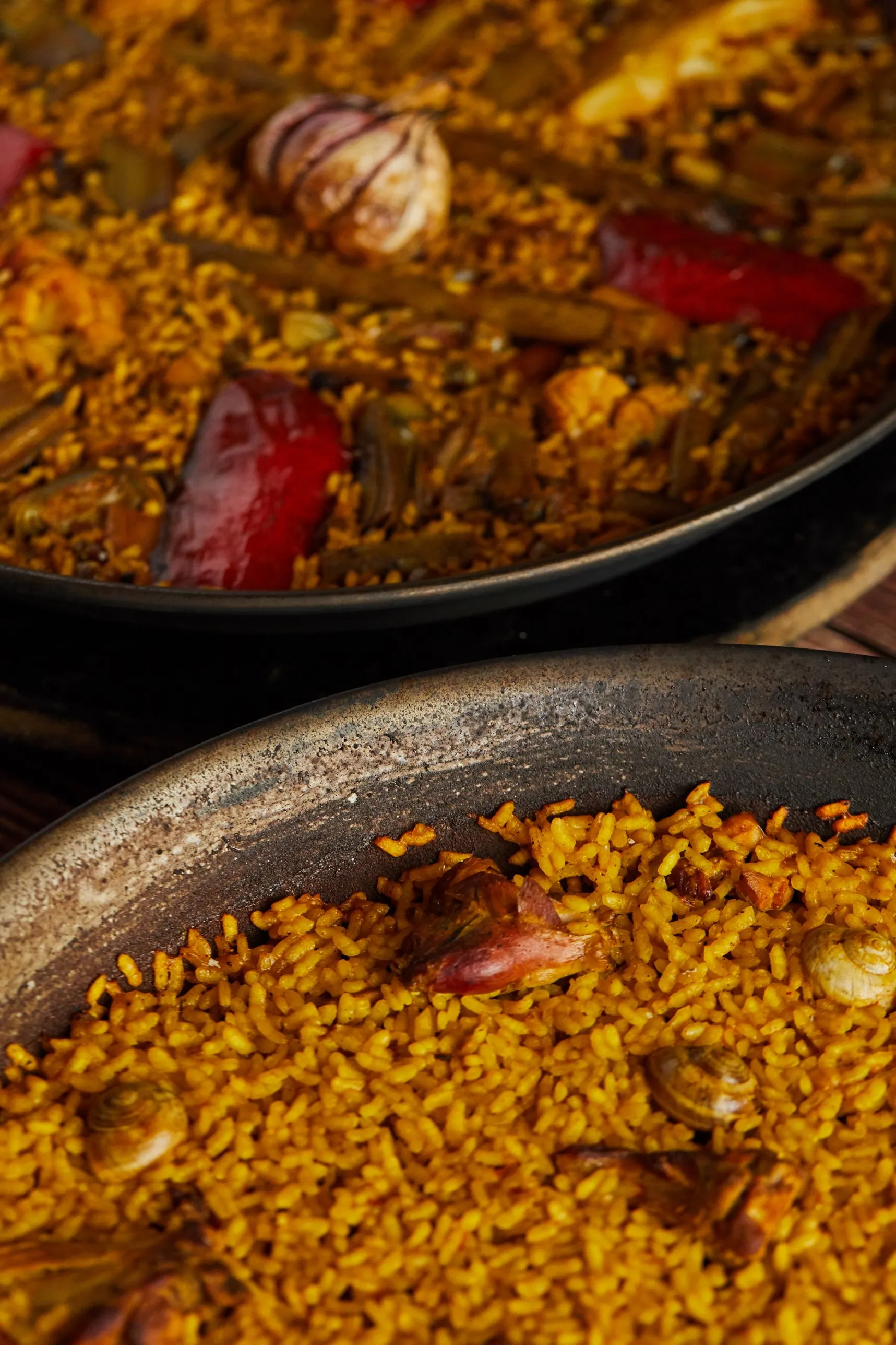 Vegetable rice and rabbit and snail rice in their paella pans