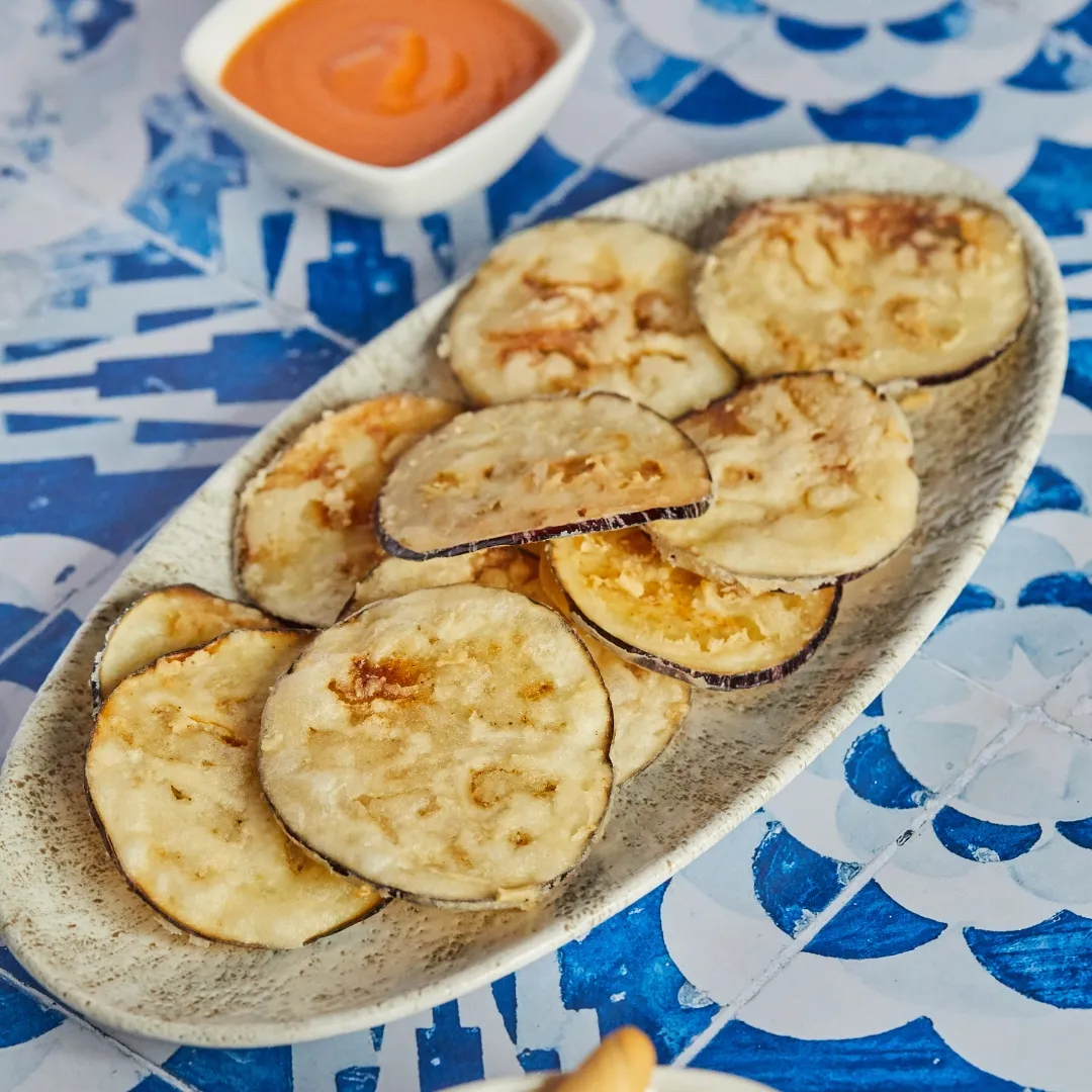 Fried aubergine with salmorejo on a tiled table